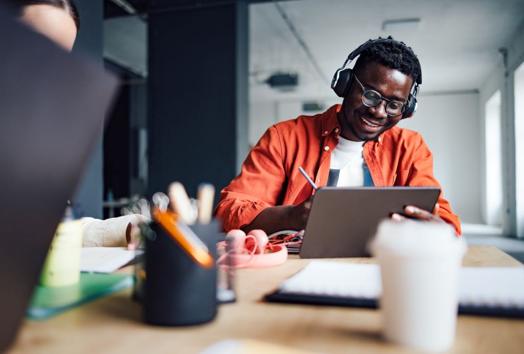 Personne assise à un bureau devant une tablette