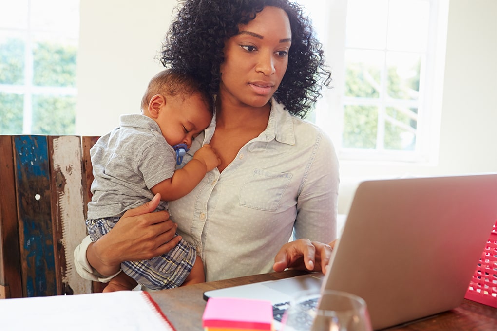 Mother sitting holding her baby on the table 
