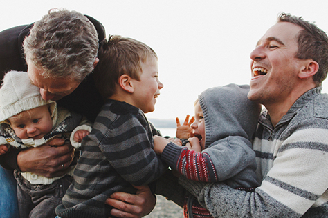 Family playing and laughing on a beach 