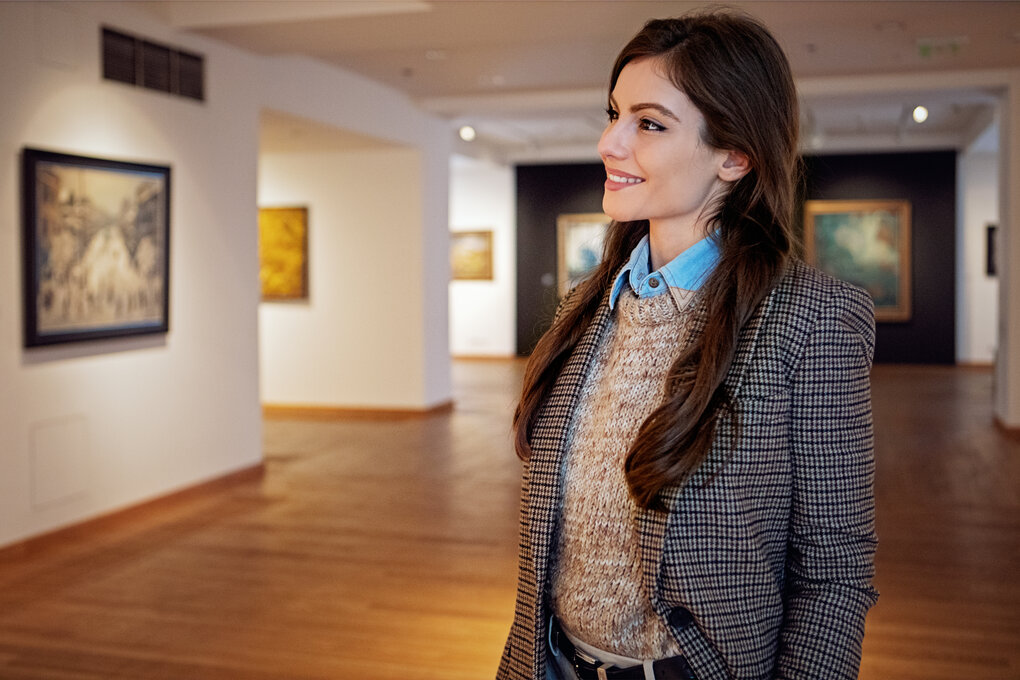 A woman looking at a work of art in an art gallery