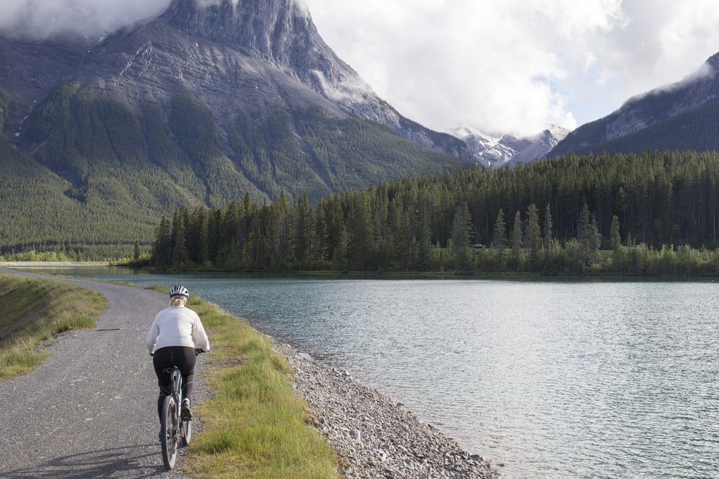 Person biking alongside a lake 