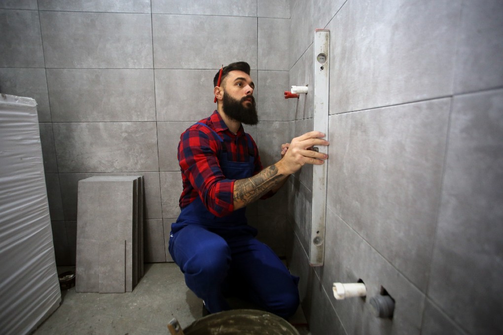 A worker builds a ceramic wall with a tax credit.