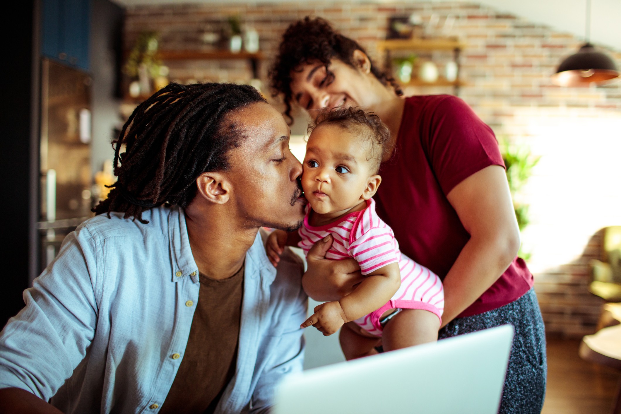 A couple plays with their child in the living room.