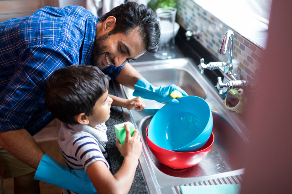 Photo of a man and his son cleaning dishes 