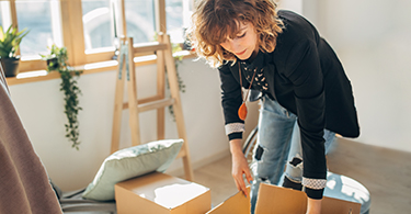 Image of a young woman unpacking boxes