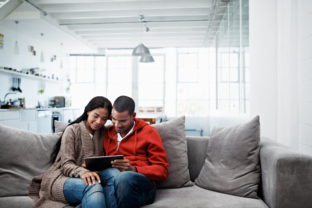 A seated couple discusses their expenses