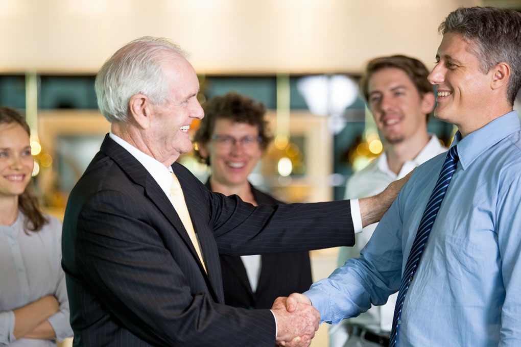 Smiling Business Leader Congratulating Colleague