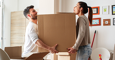Couple carrying a large moving box 