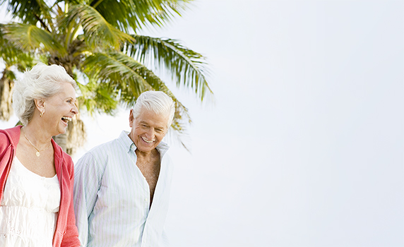 Elderly couple smiling and laughing together on the beach in Florida 