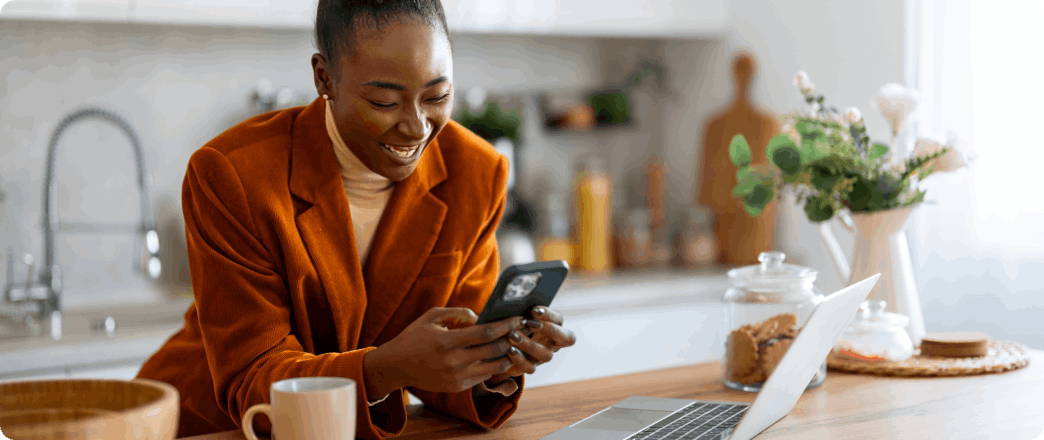 Photo of a person looking at their mobile phone and smiling 