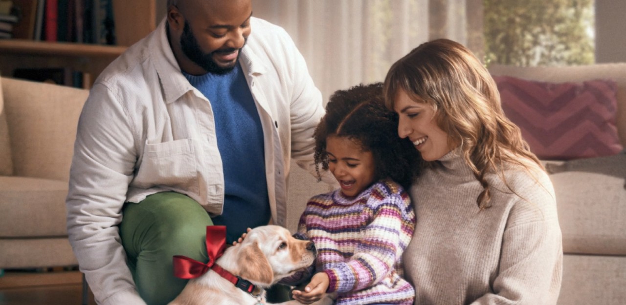 Photo of a family sitting on the floor with a dog