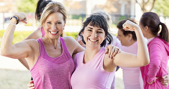 Photo of two women at the end of a marathon, fists raised as a sign of strength